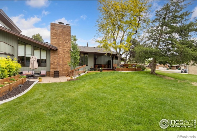 4456 W Pioneer Dr, Greeley, CO 80634 - view of grassy yard with a patio and a vegetable garden