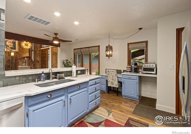 4456 W Pioneer Dr, Greeley, CO 80634 - kitchen with blue cabinets, a sink, light wood-style flooring, light countertops, and recessed lighting