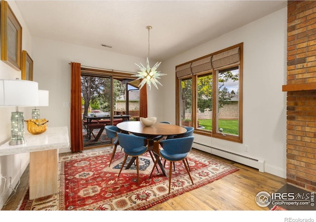 4456 W Pioneer Dr, Greeley, CO 80634 - dining space featuring baseboard heating, light wood-type flooring, healthy amount of natural light, and baseboards