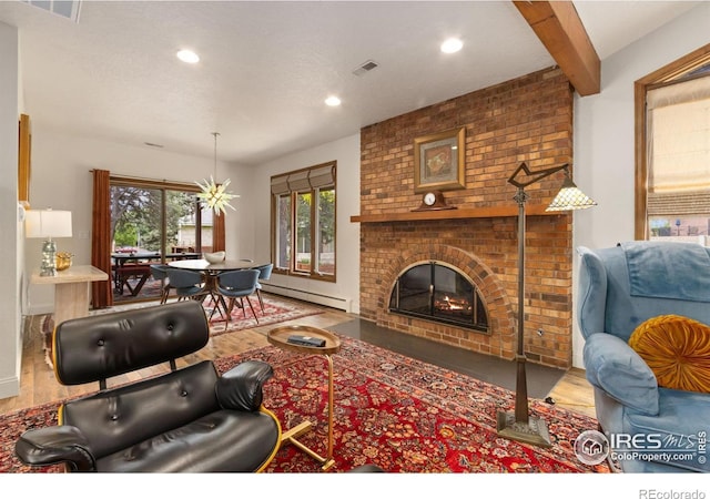 4456 W Pioneer Dr, Greeley, CO 80634 - living room with wood finished floors, a baseboard radiator, a brick fireplace, and recessed lighting