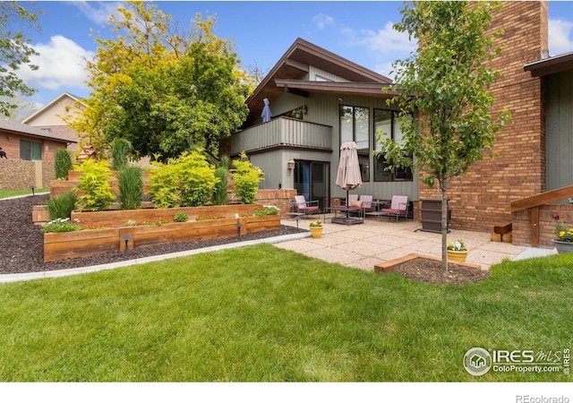 4456 W Pioneer Dr, Greeley, CO 80634 - rear view of property featuring a balcony, a lawn, a garden, and a patio