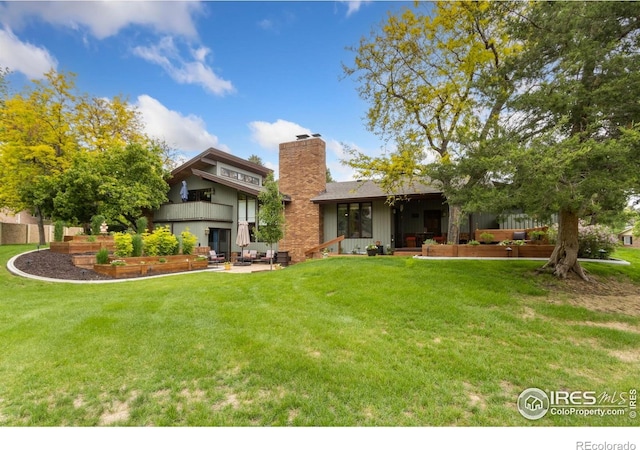 4456 W Pioneer Dr, Greeley, CO 80634 - rear view of property with a chimney and a yard