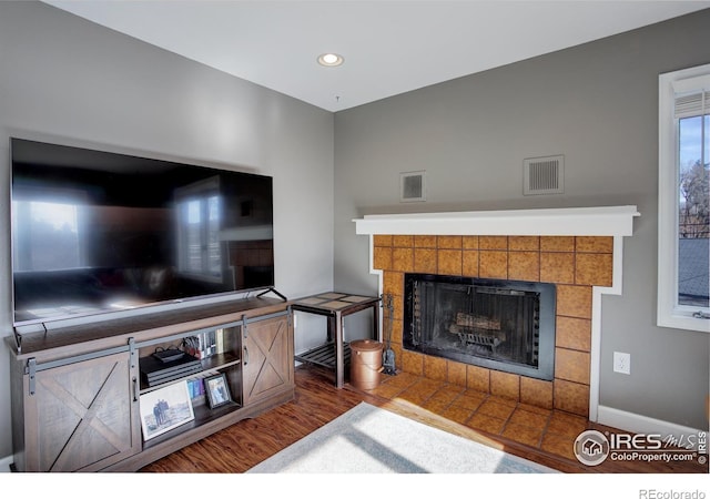 400 Emery St Unit 208, Longmont, CO 80501 - living area with a tiled fireplace, wood finished floors, recessed lighting, and baseboards