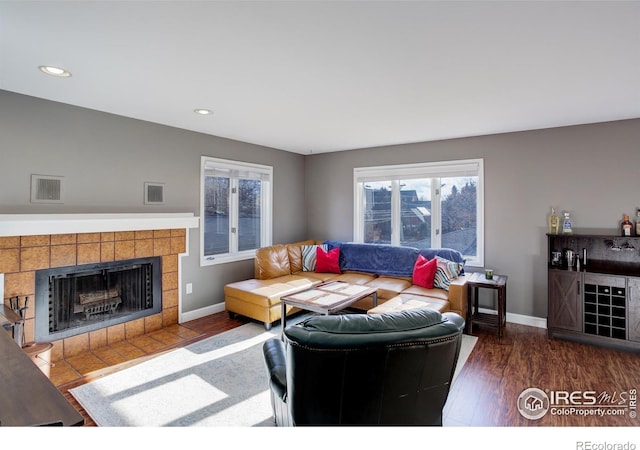 400 Emery St Unit 208, Longmont, CO 80501 - living room featuring wood finished floors, a tile fireplace, recessed lighting, and baseboards