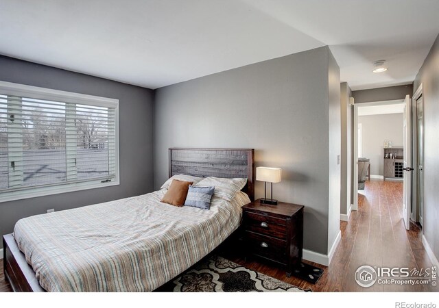 400 Emery St Unit 208, Longmont, CO 80501 - bedroom featuring baseboards and wood finished floors