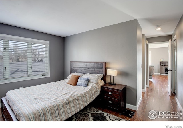 400 Emery St Unit 208, Longmont, CO 80501 - bedroom featuring baseboards and wood finished floors