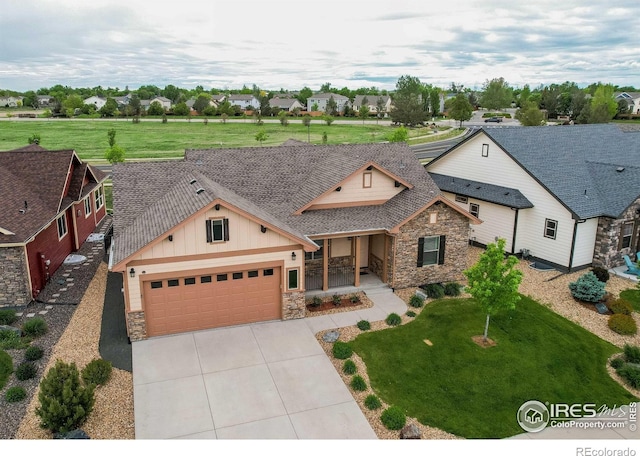 3570 Saguaro Dr, Loveland, CO 80537 - view of front of property with stone siding, board and batten siding, concrete driveway, covered porch, and an attached garage