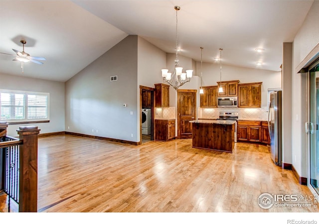 3570 Saguaro Dr, Loveland, CO 80537 - kitchen featuring stainless steel appliances, washer / dryer, ceiling fan, open floor plan, and a chandelier