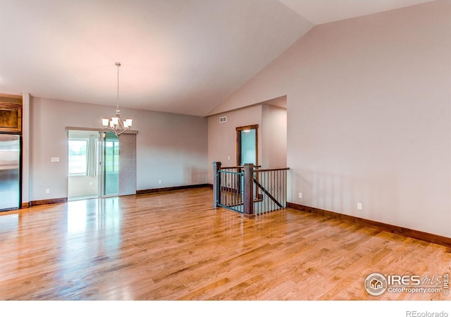 3570 Saguaro Dr, Loveland, CO 80537 - spare room with a chandelier, light wood finished floors, baseboards, and high vaulted ceiling