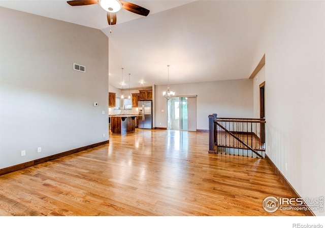3570 Saguaro Dr, Loveland, CO 80537 - unfurnished living room with a chandelier, ceiling fan, light wood-style flooring, high vaulted ceiling, and baseboards