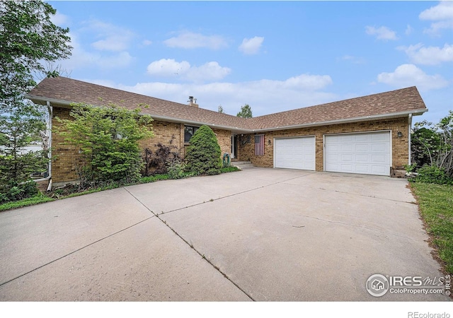 4601 N Sunshine Ct, Loveland, CO 80537 - ranch-style house featuring driveway, an attached garage, brick siding, and a chimney
