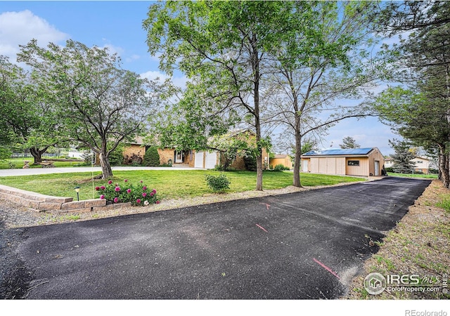 4601 N Sunshine Ct, Loveland, CO 80537 - view of front of house with a front lawn, roof mounted solar panels, and asphalt driveway