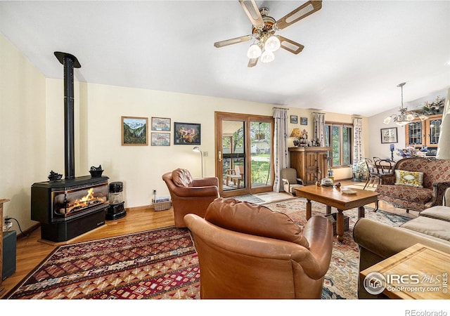 4601 N Sunshine Ct, Loveland, CO 80537 - living room with ceiling fan, a wood stove, wood finished floors, vaulted ceiling, and a chandelier