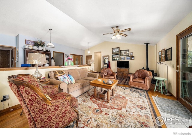 4601 N Sunshine Ct, Loveland, CO 80537 - living room featuring wood finished floors, a wood stove, lofted ceiling, and a ceiling fan