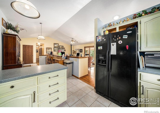 4601 N Sunshine Ct, Loveland, CO 80537 - kitchen featuring black refrigerator with ice dispenser, vaulted ceiling, light tile patterned floors, a ceiling fan, and hanging light fixtures