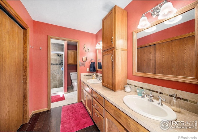 4601 N Sunshine Ct, Loveland, CO 80537 - full bathroom with toilet, double vanity, a stall shower, and wood finished floors