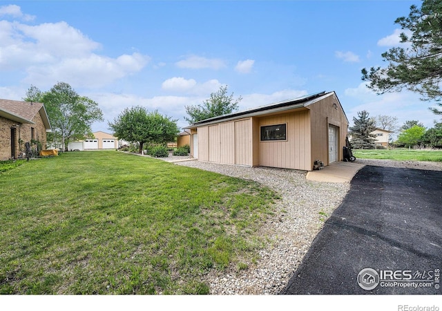 4601 N Sunshine Ct, Loveland, CO 80537 - view of property exterior featuring a yard, an outdoor structure, and a garage