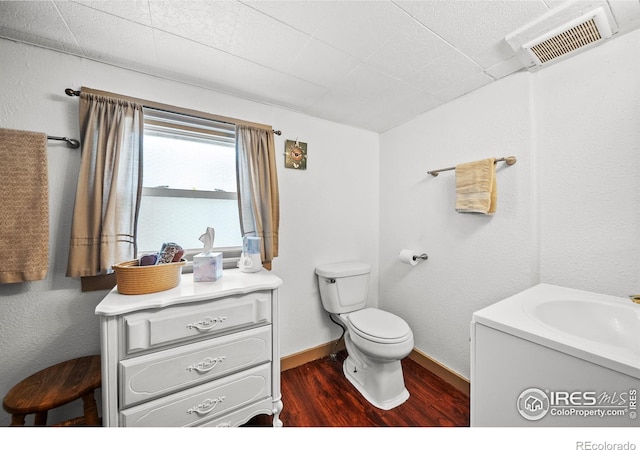 513 N 2nd Ave, Sterling, CO 80751 - bathroom with wood finished floors, vanity, toilet, and baseboards