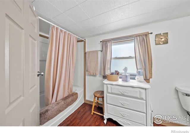513 N 2nd Ave, Sterling, CO 80751 - full bathroom with wood finished floors, shower / bath combination with curtain, and toilet