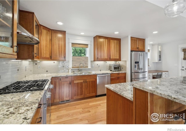 2917 13th St, Boulder, CO 80304 - kitchen with appliances with stainless steel finishes, a sink, light wood-style floors, brown cabinets, and decorative backsplash