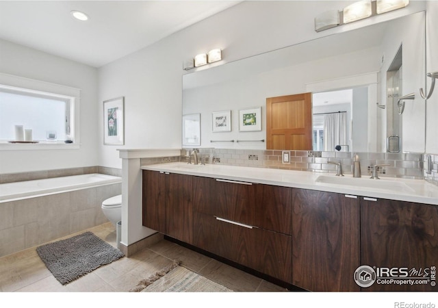 2917 13th St, Boulder, CO 80304 - full bath with double vanity, backsplash, toilet, a relaxing tiled tub, and recessed lighting