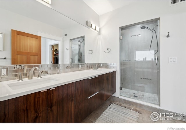 2917 13th St, Boulder, CO 80304 - bathroom featuring a stall shower, tasteful backsplash, a walk in closet, and double vanity