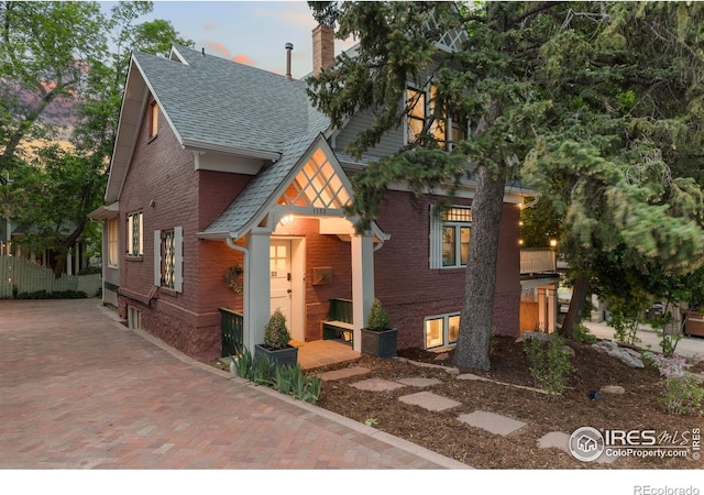 1133 Mapleton Ave, Boulder, CO 80304 - view of front facade featuring roof with shingles, brick siding, and a chimney