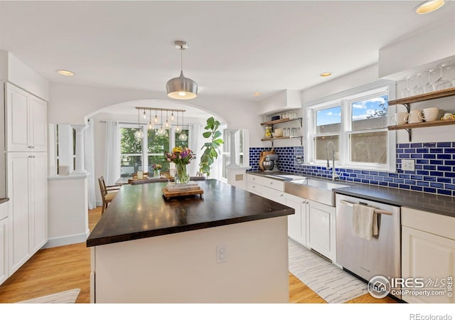 1133 Mapleton Ave, Boulder, CO 80304 - kitchen featuring stainless steel dishwasher, open shelves, a sink, arched walkways, and light wood-style floors