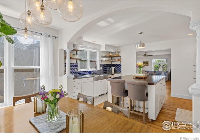 1133 Mapleton Ave, Boulder, CO 80304 - kitchen with decorative columns, backsplash, dark countertops, and white cabinets