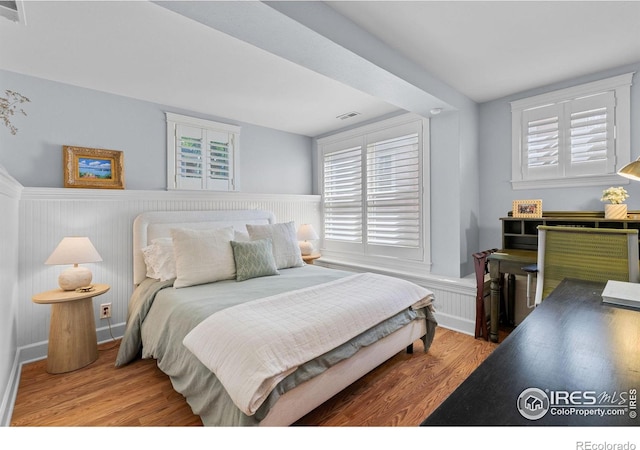 1133 Mapleton Ave, Boulder, CO 80304 - bedroom with a wainscoted wall, wood finished floors, and multiple windows