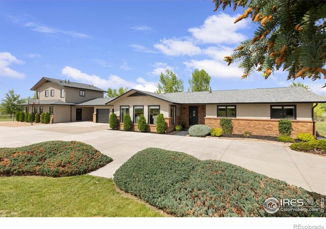 1119 Wrangler Way, Loveland, CO 80537 - view of front of home with concrete driveway, stucco siding, an attached garage, and a front lawn