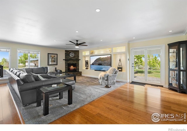 1119 Wrangler Way, Loveland, CO 80537 - living room featuring wood finished floors, plenty of natural light, a ceiling fan, crown molding, and recessed lighting