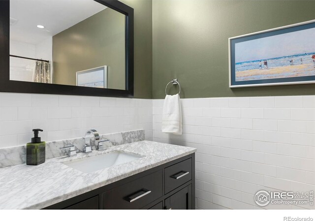 1119 Wrangler Way, Loveland, CO 80537 - full bathroom featuring vanity, tile walls, and a shower with curtain