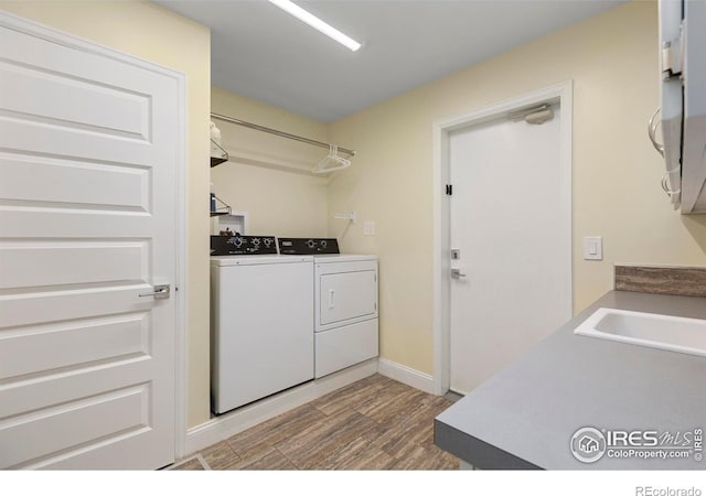 1119 Wrangler Way, Loveland, CO 80537 - laundry area featuring washing machine and clothes dryer, wood finished floors, and baseboards
