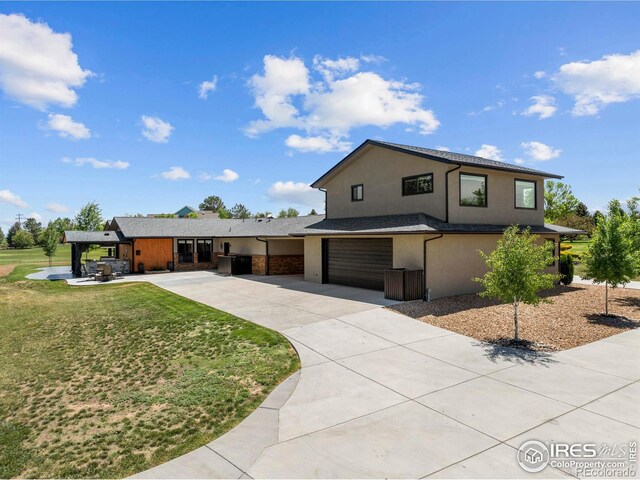 1119 Wrangler Way, Loveland, CO 80537 - view of front of house with concrete driveway, a front lawn, a garage, and stucco siding