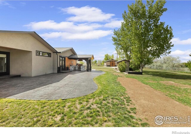 1119 Wrangler Way, Loveland, CO 80537 - view of grassy yard featuring a patio