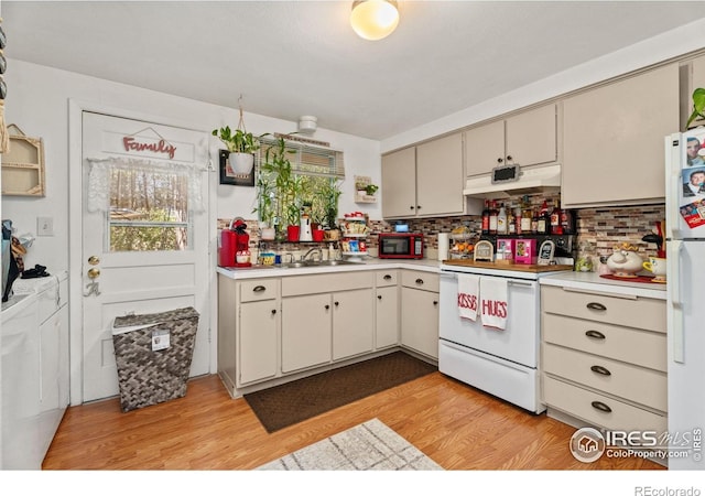 kitchen with white appliances, light countertops, under cabinet range hood, and light wood-style flooring
