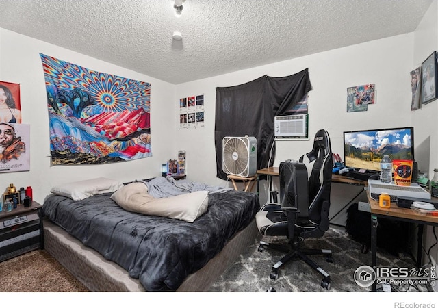 carpeted bedroom with a textured ceiling, cooling unit, and a desk
