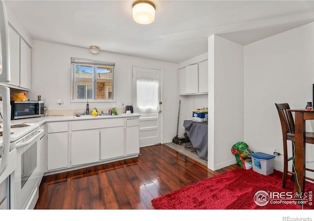 kitchen with stainless steel microwave, a sink, white electric range, light countertops, and dark wood-type flooring