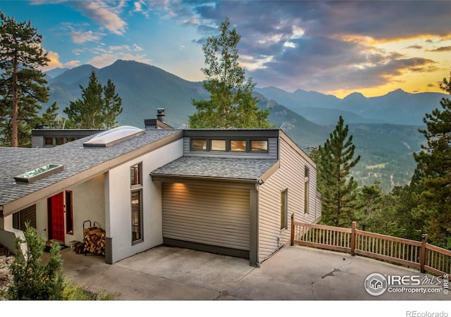 1561 St Moritz Trl, Estes Park, CO 80517 - view of front of house featuring driveway, a mountain view, and roof with shingles