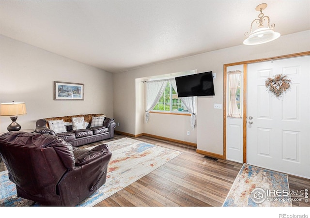 2325 42nd Avenue Ct, Greeley, CO 80634 - living room featuring wood finished floors, baseboards, and vaulted ceiling