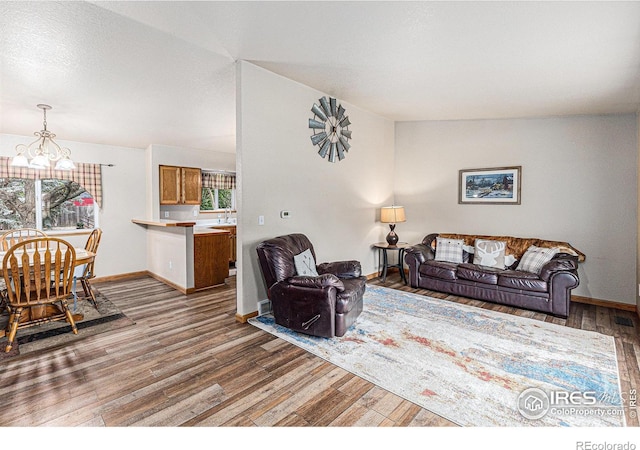 2325 42nd Avenue Ct, Greeley, CO 80634 - living room featuring a chandelier, wood finished floors, and baseboards