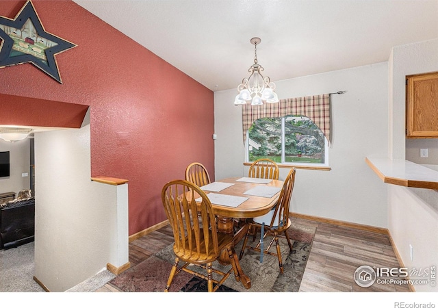 2325 42nd Avenue Ct, Greeley, CO 80634 - dining room with a chandelier, wood finished floors, and baseboards