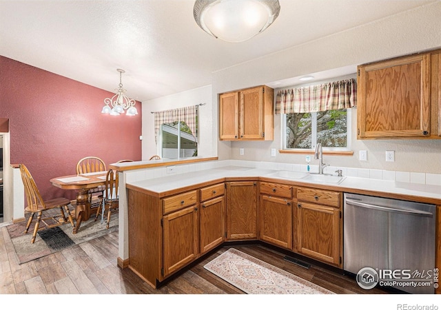 2325 42nd Avenue Ct, Greeley, CO 80634 - kitchen with stainless steel dishwasher, a sink, a peninsula, wood finished floors, and light countertops