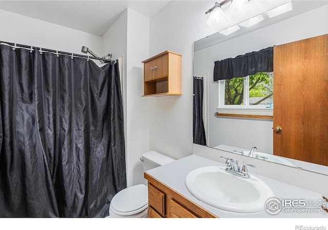2325 42nd Avenue Ct, Greeley, CO 80634 - bathroom with toilet, vanity, and curtained shower