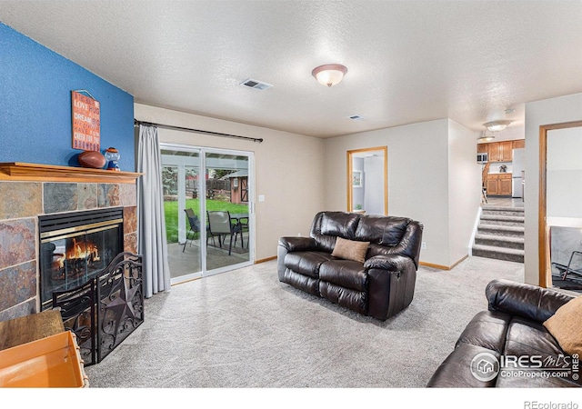 2325 42nd Avenue Ct, Greeley, CO 80634 - carpeted living area with a glass covered fireplace, a textured ceiling, baseboards, and stairway