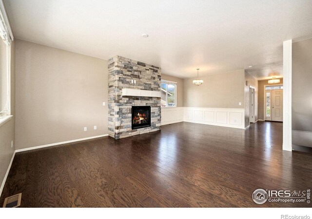 6071 Moran Rd, Timnath, CO 80547 - unfurnished living room with wood finished floors and a stone fireplace
