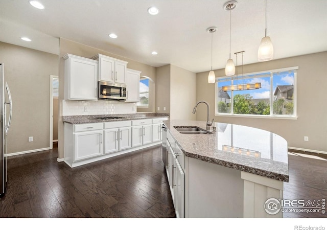 6071 Moran Rd, Timnath, CO 80547 - kitchen featuring a sink, appliances with stainless steel finishes, baseboards, white cabinetry, and light stone counters