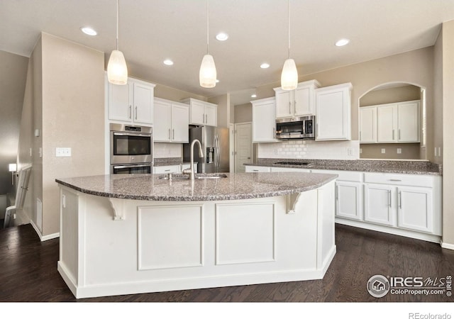 6071 Moran Rd, Timnath, CO 80547 - kitchen with appliances with stainless steel finishes, a sink, white cabinetry, dark wood-style floors, and recessed lighting