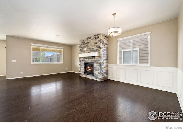 6071 Moran Rd, Timnath, CO 80547 - unfurnished living room featuring dark wood-style floors and a stone fireplace